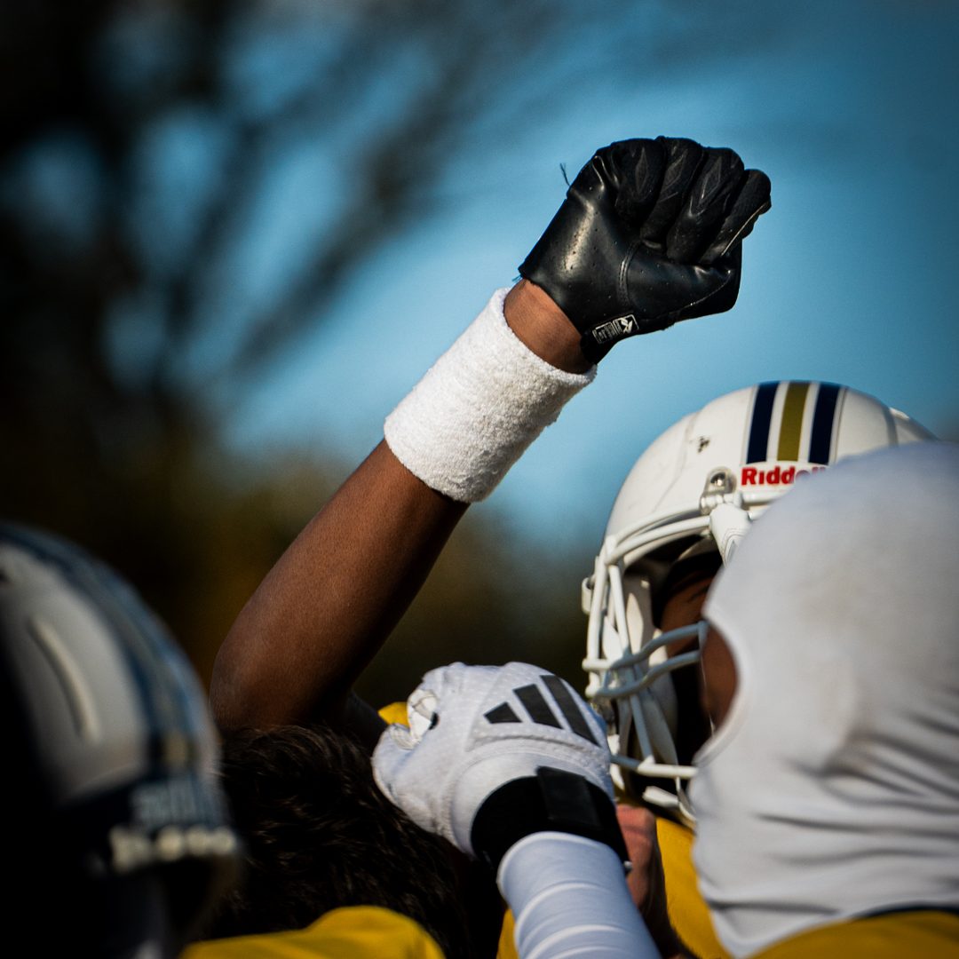Team moment in American football – player raising hand after briefing