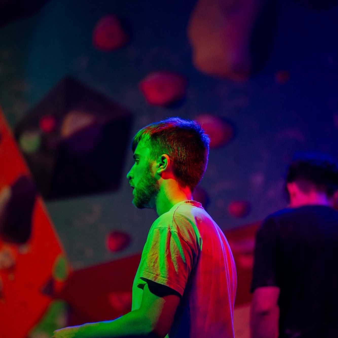 Two climbers focus on a climb at a london uv party 